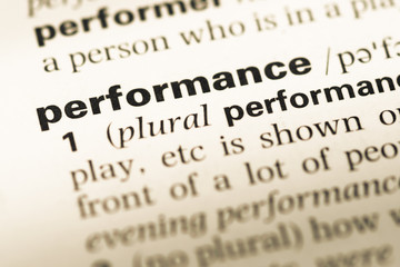 Obraz premium Close up of old English dictionary page with word performance