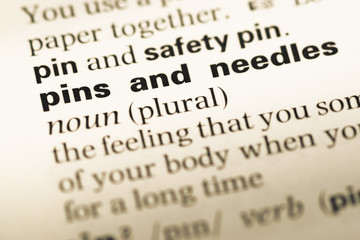 Fototapeta premium Close up of old English dictionary page with word pins and needl