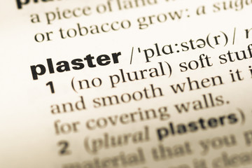 Obraz premium Close up of old English dictionary page with word plaster