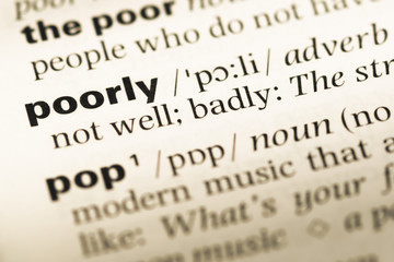 Obraz premium Close up of old English dictionary page with word poorly