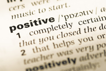 Fototapeta premium Close up of old English dictionary page with word positive