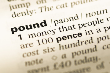 Obraz premium Close up of old English dictionary page with word pound