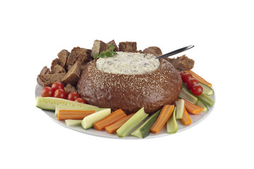 spinach dip on pumpernickel bread with bread cubes and vegetables slices