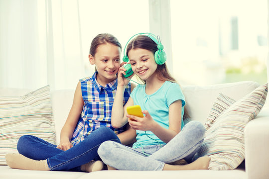 happy girls with smartphone and headphones