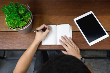 business man hand using laptop and write note inspire idea on wo