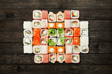 Set of sushi maki and rolls at black rustic wood.