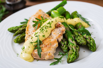 Baked chicken garnished with asparagus and herbs - obrazy, fototapety, plakaty