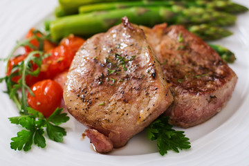 Barbecue grilled beef steak meat with asparagus and tomatoes.