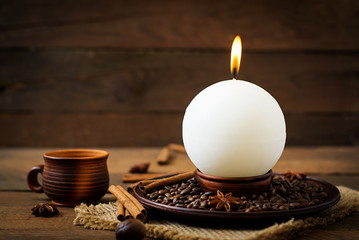Candle in the shape of balls and coffee on the old wooden background