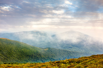 cold fog on hot sunrise in mountains