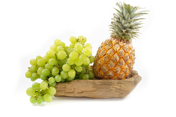 A Pineapple and Grapes on Wood Plate Isolated, white background