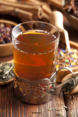 Glass of tea and dried tea leaves
