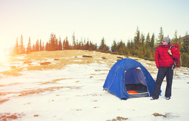 A climber with a backpack near the tent.