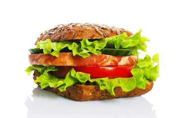 Sandwich with cereals bread, with ham and vegetables, green salad on a white background. Fast food.