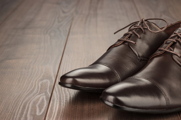 brown leather shoes on the wooden background