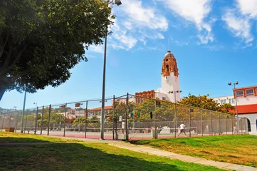Fotobehang San Francisco: la Missione di San Francesco d'Assisi vista attraverso un campo da tennis nel parco di Mission Dolores Park © Naeblys