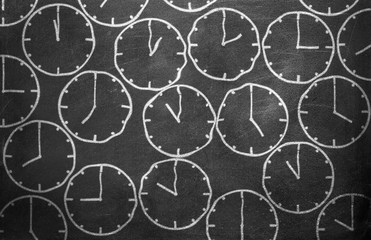 Clock from chalk on black chalkboard background texture
