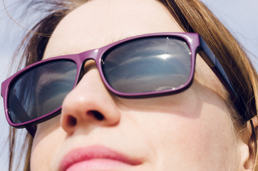 kobieta w słonecznych okularach patrzy w słońce
