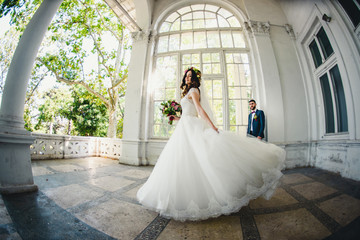 incredible bride in a beautiful dress posing in front of husband