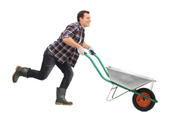 Man pushing wheelbarrow and running