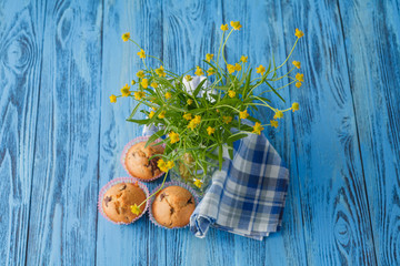Homemade muffins in blue napkin on blue wood table