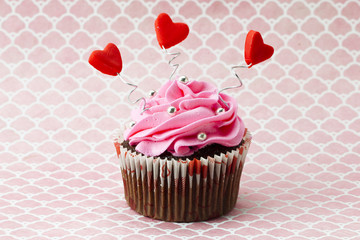 close-up image of strawberry cupcake with heart shape and candy beads.