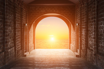 Walkway tunnel made by red brick and view of sunset or sunrise