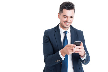 Cheerful business man using cellphone for sending a message