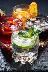 assortment of iced fruit drinks on a dark background, vertical