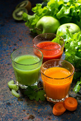 glasses of fresh vegetable juice from carrots, tomatoes and herb