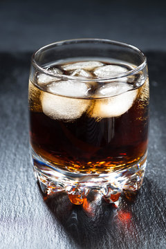 cola with ice in a glass, vertical