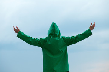 Back view of woman standing in raincoat hand up © antgor