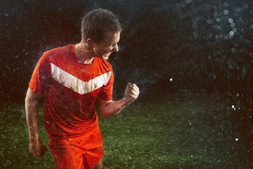 Rolgordijnen Voetballer viert overwinning in de regen © lassedesignen