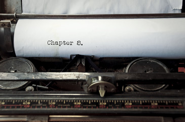 close up image of typewriter with paper sheet and the phrase: chapter 8. copy space for your text. retro filtered 