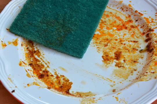 Green Scrub Sponge Wipe Food Stain On White Dish