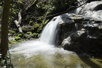 Wasserfall Fliesst über Felsgestein in den Weiher