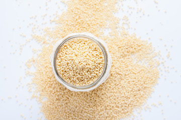 Пшено в банке на белом фоне.