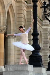 Graceful ballerina in white tutu and corset dancing in front of a palace