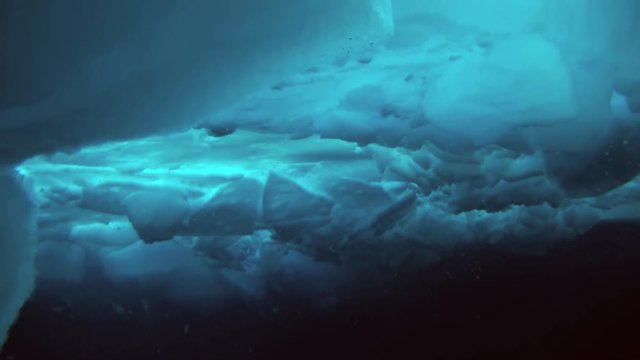 Unique extreme underwater shooting scuba dive beneath ice at geographic  North Pole in cold waters. Fantastic views of the lump of ice in water. ICE CAMP BARNEO, NORTH POLE, ARCTIC - APRIL 2015