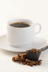 Coffee beans with cup of coffee on background