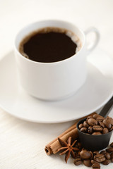 Coffee beans with cup of coffee on background