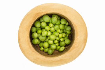Fresh green peas in wooden bowl closeup, isolated on white background