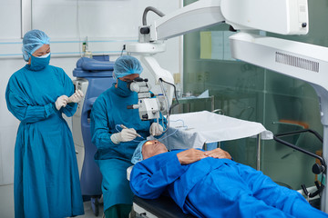 Surgeon and his assistant performing operation  on eye