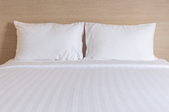 White bedding sheets and pillow in hotel room