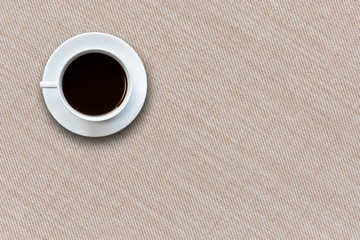 White coffee cup on fabric background top view