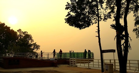 Nong Khai province, Thailand- April 28,2016: Tourists walking on transparent  sky walk to see view of Mekong River during sunset at Wat Pha Tak Suea. The first transparent sky walk in thailand.