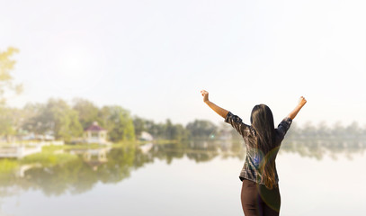 Rare view of women standing and raising arms embrace nature lake