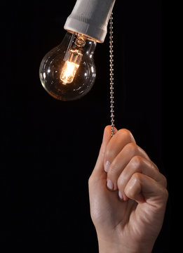 mano encendiendo una bombilla, apagando,encendiendo una lampara