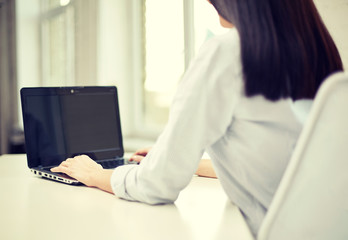 close up of woman typing on laptop at office