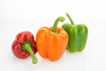 Fresh orange, green and red bell peppers, isolated on white background.